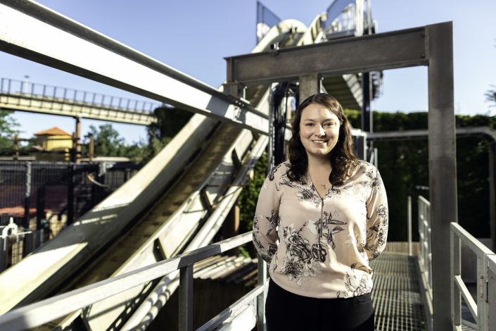 Engineer standing in front of roller coaster