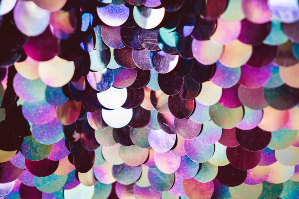 Shiny section of multi-coloured plastic sequined fabric.