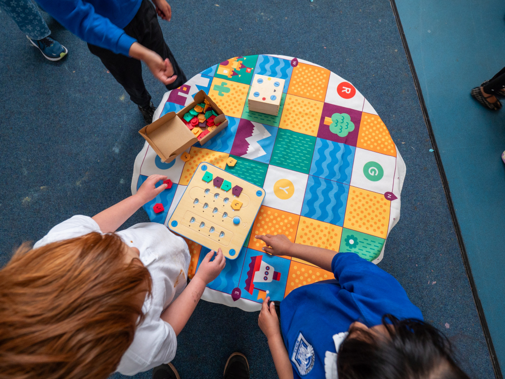 Children using Cubetto tiles correctly in the programming board.