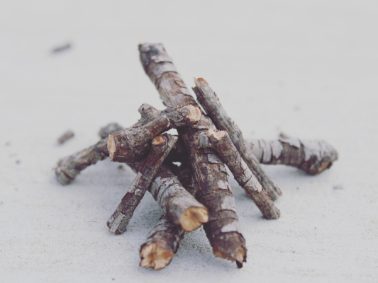 A small pyramid pile of sticks in the snow.