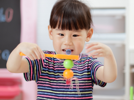 A young child plays with a magnetic toy.