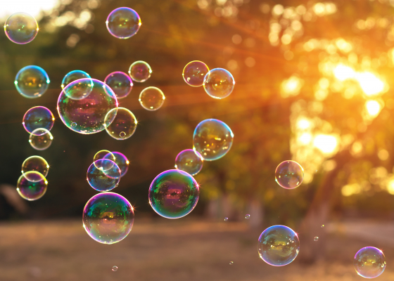 A variety of sizes of bubbles floating in the air.