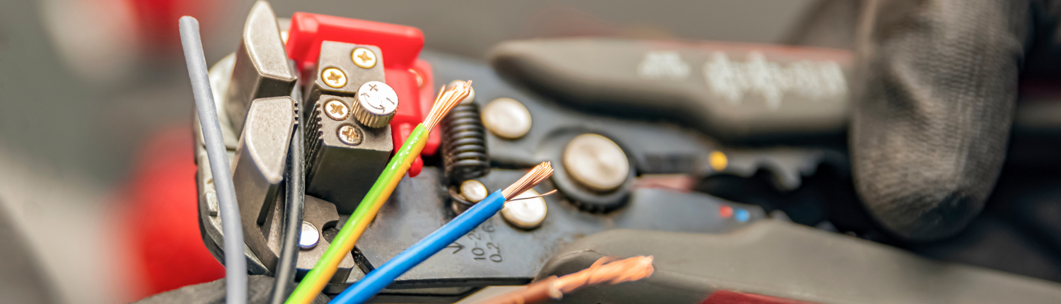 Wire strippers. The electrician cleans the protective insulation from the wire using a wire stripper. The process of connecting wires. close-up